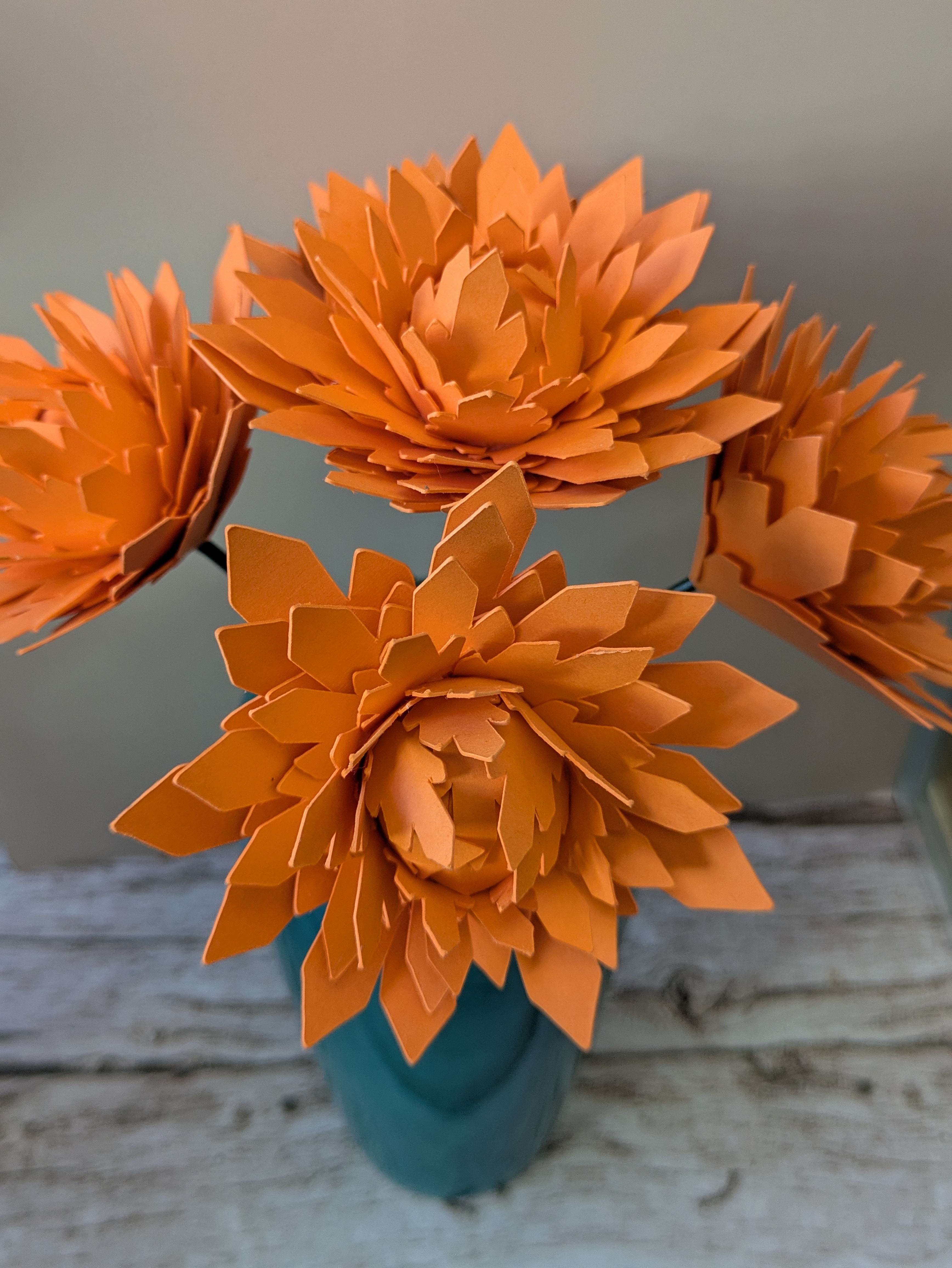 Bouquet de dahlias orange vase bleu